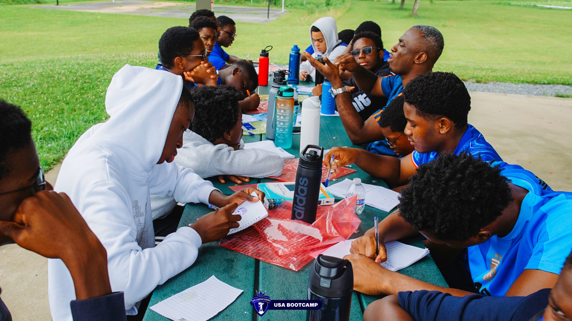 Boys working around a picnic table on a group activity.