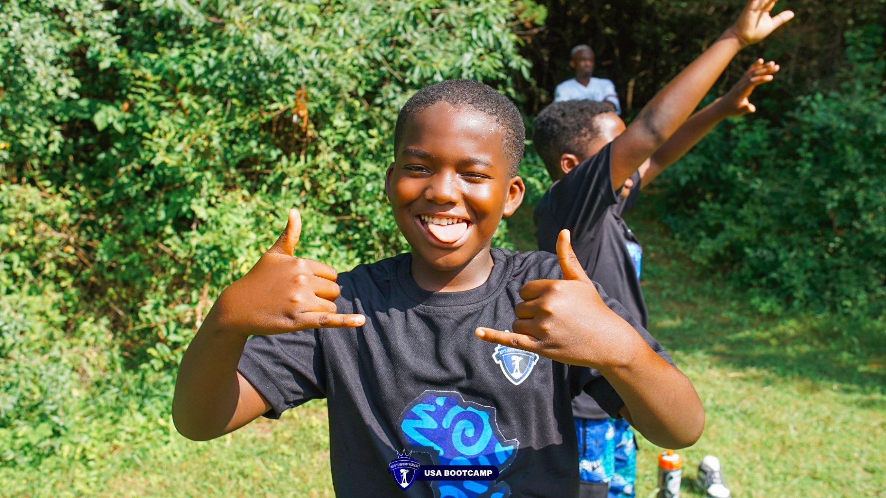 A camper smiling and throwing shakas to the camera.