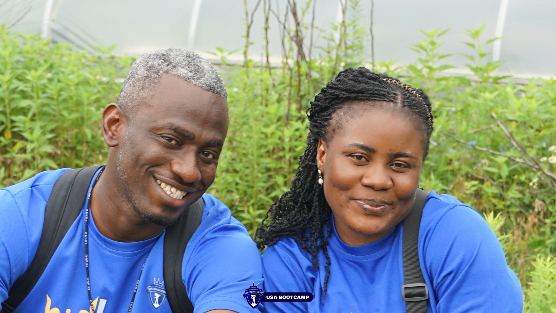 Coach Ebuka Ede and Coach Ruth Ede smiling together at the BLA USA Boot Camp, wearing blue Boys Leadership Academy shirts.