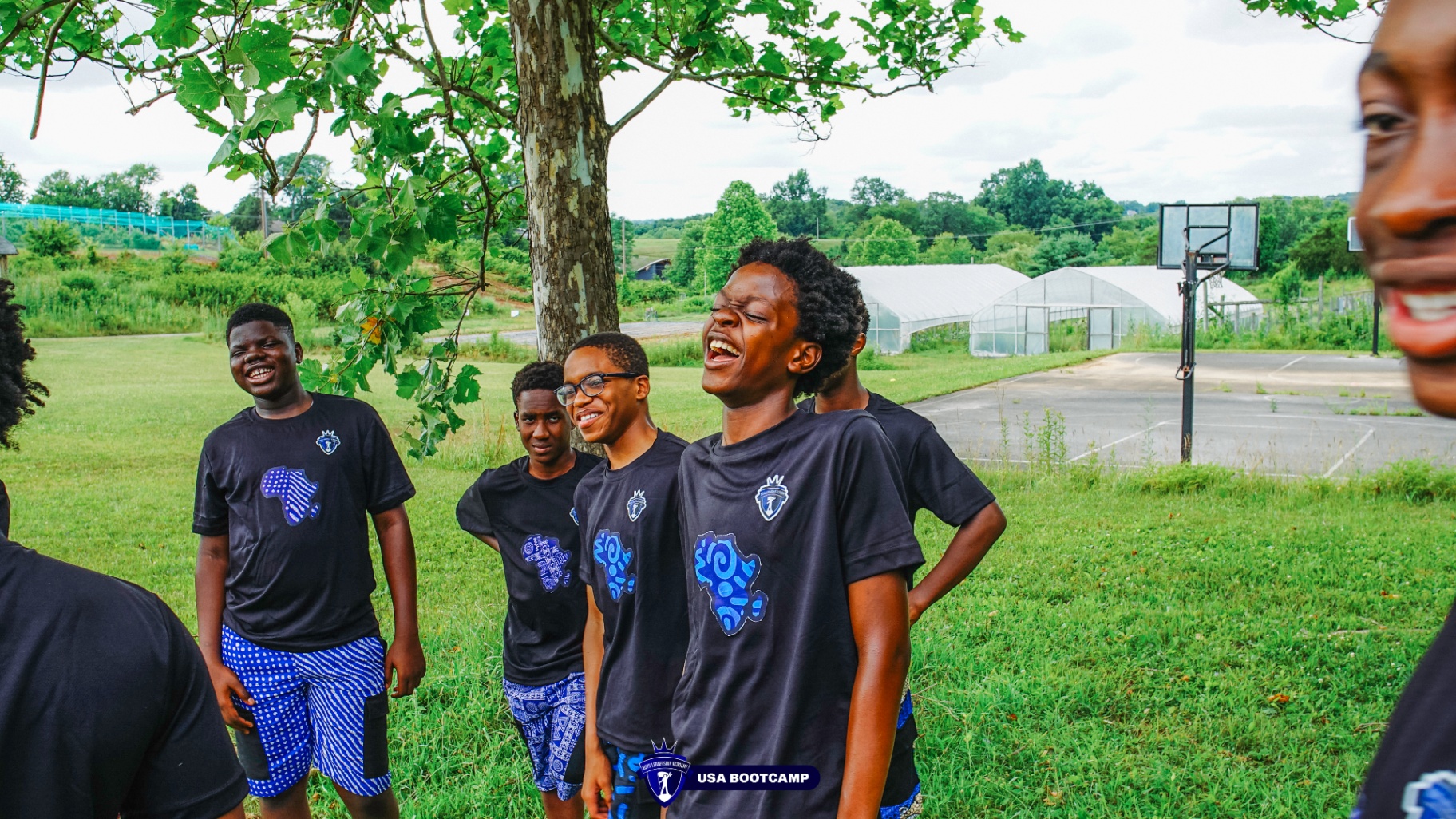 A group of campers laughing together under a tree.