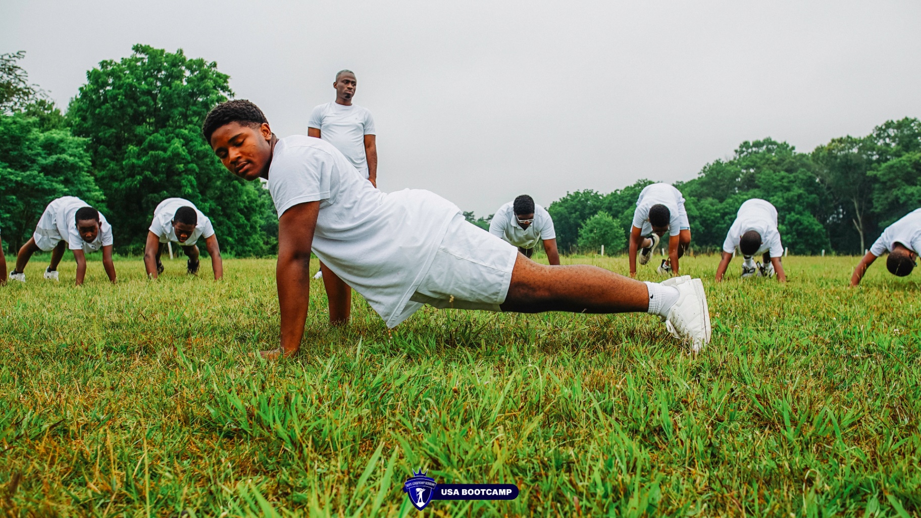 Boys doing push-ups in a field during BLA USA Boot Camp.