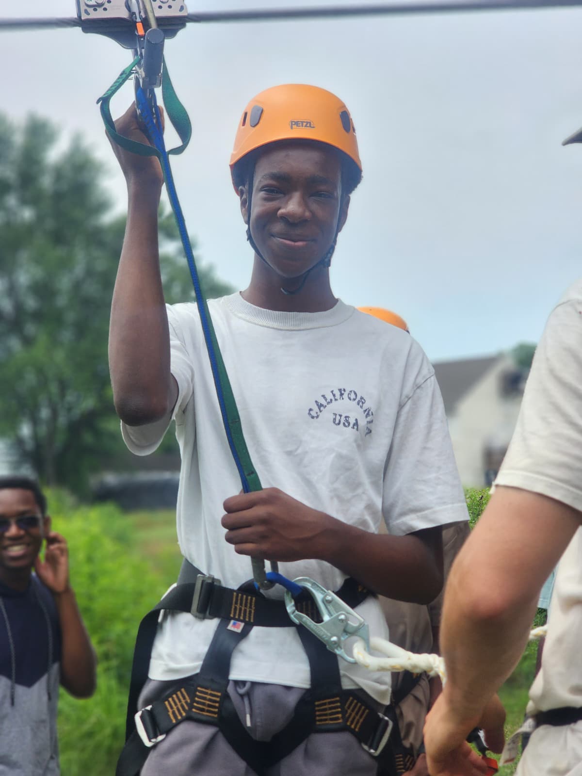 A camper in helmet and harness ready to ride the zip line.